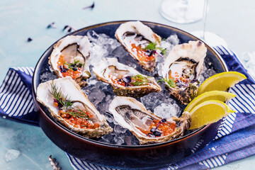 Tasty oysters on ice with lemon.
Refined with herbs and salmon caviar.