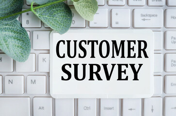 customer survey. text on white paper on computer keyboard