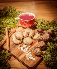 Homemade Christmas biscuits and steaming tea on wooden table