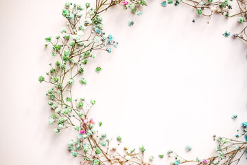 small multi-colored flowers with baby's breath arranged in a circle shape of the wreath . flat lay. top view. copy space. special focus. close up.