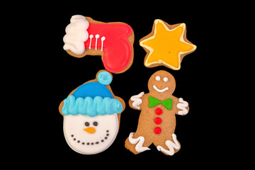 Group of tasty christmas print cookies isolated on black background.