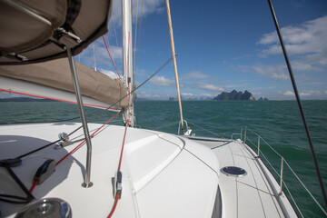View of the blue sea water from the side of a sailboat with rigging and sails. Tackle barge, sail, masts, yards, deck, ropes,