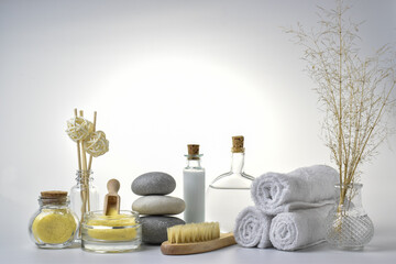 Composition with a candle and Spa stones and a natural brush for body massage on a light background. The concept of skin care. Bath accessories.