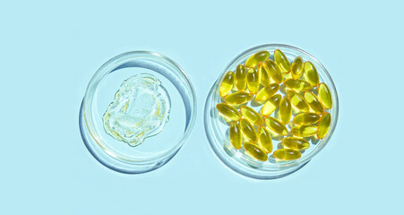 Omega3 gel capsule. Yellow vitamin. Health eating. Dietology drug. Fish oil supplement. Microdosing concept. Golden color softgel collagen. Blue background. Two bowl. Medicine immunity cosmetics