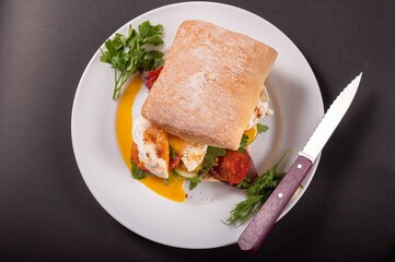 Sandwich with white bun and poached egg. Sandwich and knife. Flat lay.
