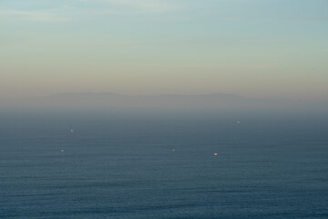 View of Lisbon on the middle of the fog at sunrise seen from Cabo Espichel Cape, in Portugal