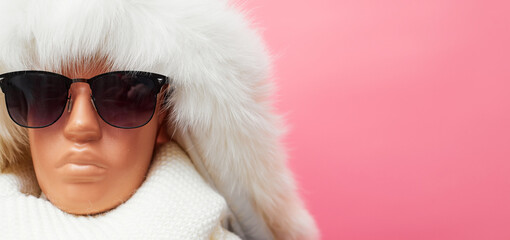 mannequin with glasses and a scarf, discounts on winter clothes and accessories, on a pink background, banner, copy space