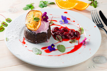Rich chocolate fondant served with ice cream, fresh strawberries and mint, chocolate fondue with a scoop of ice cream