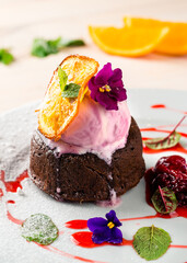 Rich chocolate fondant served with ice cream, fresh strawberries and mint, chocolate fondue with a scoop of ice cream