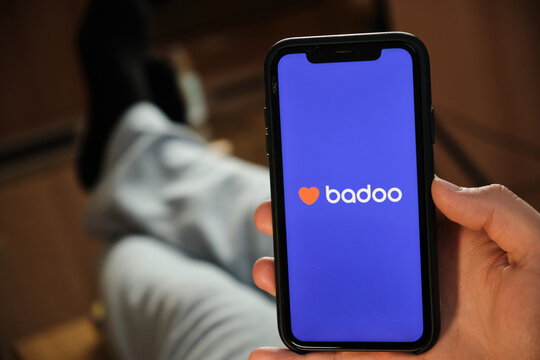 Badoo application on the smartphone in mans hand. Man laying and using application for dating and meeting. Social network concept, July 2020, Prague, Czech Republic.