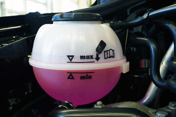 Expansion tank mounted on the engine of a modern car