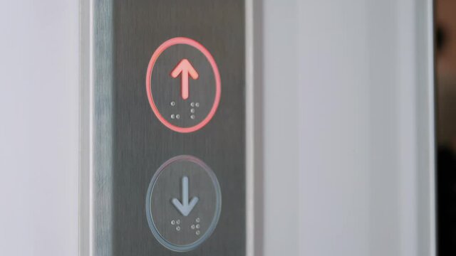 Slow motion: woman finger pressing elevator up button on lift control panel at mall, hotel or business center - close up view. Technology, moving up, progress, growth and success concept