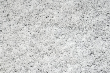 White snow covered black surface. Snow on the ground.
