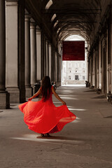 donna in rosso sotto i portici degli Uffizi a Firenze