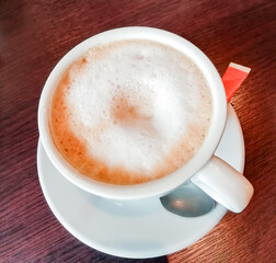 Foam in fresh and hot coffee with milk top view.