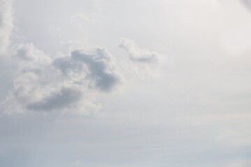 Gray fluffy cloud on a pale grey sky background