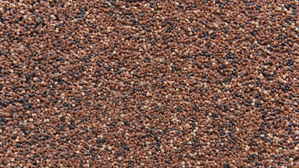 Multi-colored wall formed from small stones. Interesting abstract background pattern for your construction project. Individual outside surface finish at home. Decorative texture of the house wall. 