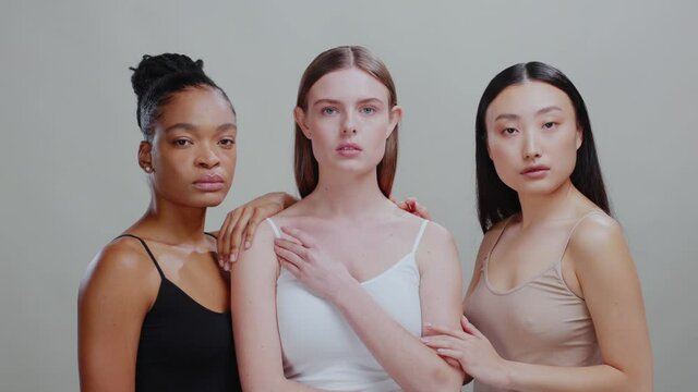 Nude portrait of beautiful three multi-ethnic young women posing at grey background. Diversity. Cosmetic concept. Beauty skincare.