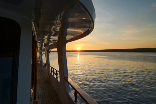 beautiful and spectacular sunset over a motor yacht with reflections on the white paint and details of the vessel, lying in the graet darwin bay of genovesa island, galapagos islands, Ecuador