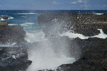 waves crushing over lava rocks on the shoreline of the galapagos islands, causing white and wild spray of sea water, Ecuador, South america 