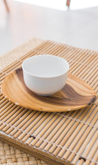 Beautiful white porcelain tea cup on a saucer close up. Vertical shot.