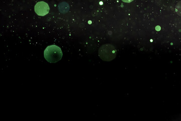 Shiny green bokeh lights on a black background
