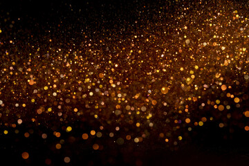 Beautiful, sparkling golden glitter pouring down from above on a dark background