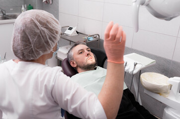 A female dentist is preparing to examine a patient in the office of a dental clinic. Concept of medicine, dentistry and healthcare. Dental equipment