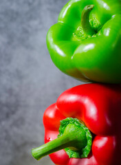 Composition with red and green bell pepper paprika on a grey background.