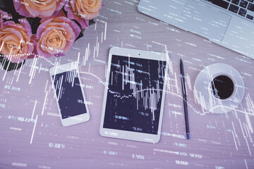 Double exposure of forex graph hologram over desktop with phone. Top view. Mobile trade platform concept.