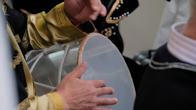 Slow motion: man hands playing ethnic azerbaijani percussion drum nagara on stage of summer open air concert - close up view. Entertainment, music, culture, leisure time and art concept