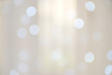 Blured warm shiny white light and bokeh effect background. Sunshine sparkling lights or morning glowing rays. Golden festive or champagne pastel beige background template.