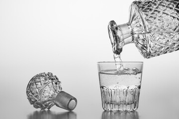 Pouring sparkling water from a carafe into a small glass. Decorative containers for serving water...
