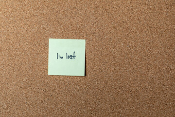 green sticker on brown table. color sticker, motivational, quote, and words, note, message I'm lost