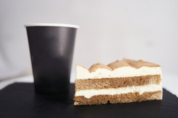 Cake with coffee on a black tray.