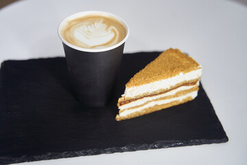 Cake with coffee on a black tray.