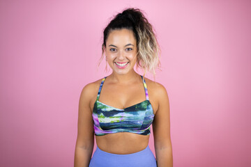 Young beautiful woman wearing sportswear over isolated pink background with a happy face standing and smiling with a confident smile showing teeth
