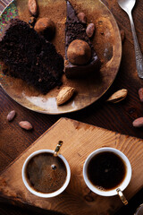 delicious chocolate truffles cakes with  cups of coffee served at dark brown wooden table . life style concept. flat lay