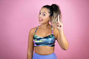 Young beautiful woman wearing sportswear over isolated pink background surprised and thinking with her finger on her head that she has an idea.