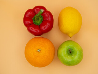 Vegetarianism, healthy food, vegetables, fruits. Red pepper, green Apple, yellow lemon, orange and grapefruit on a background of gold fortune.