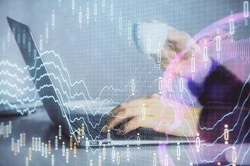 Double exposure of businesswoman hands typing on computer and forex graph hologram drawing. Financial analysis concept.