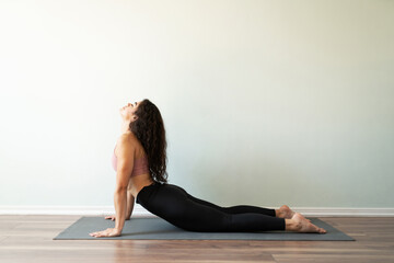 Pretty young woman relaxing her body in a yoga plow pose