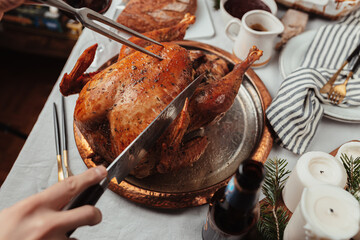Festive dinner Thanksgiving Day, Christmas dish. Holiday season, celebration with family. Festive table setting. roasted turkey, bread, potato gratin, red wine. Candles, utensils. November, December.