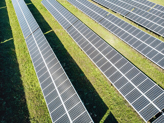 Solar panels in a field in a row. View from the drone. Solar panels under the sun. Solar energy concept