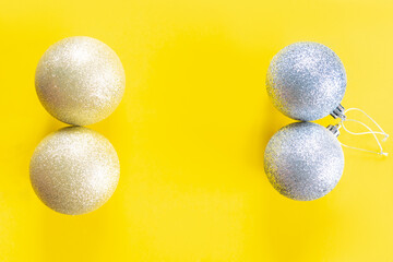christmas fortuna gold and silver balls on yellow paper background with copy space. new year flat lay decoration