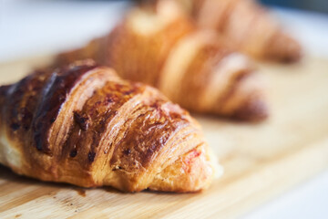 Close up of golden croissants on a wooden tray