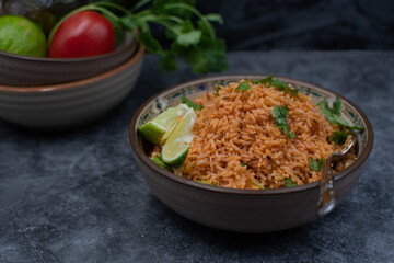 Authentic Mexican Spanish rice in ceramic bowl against gray table, copy space