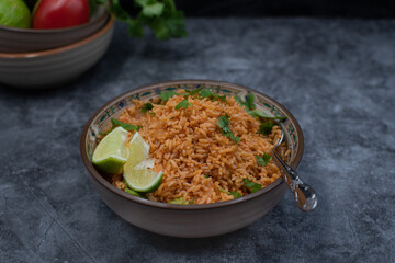 Authentic Mexican Spanish rice in ceramic bowl against gray table, copy space