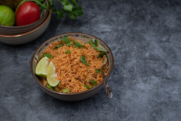 Authentic Mexican Spanish rice in ceramic bowl against gray table, copy space