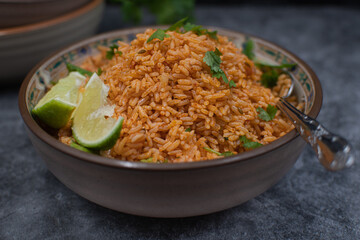 Authentic Mexican Spanish rice in ceramic bowl against gray table, copy space